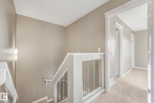 Hall with an upstairs landing and light colored carpet - 385 Secord Boulevard, Edmonton, AB - Indoor Photo Showing Other Room
