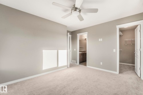 Unfurnished Master bedroom with a spacious closet, light carpet, a ceiling fan, and connected bathroom - 385 Secord Boulevard, Edmonton, AB - Indoor Photo Showing Other Room