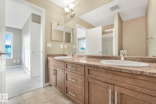 Full bath with double vanity, light carpet, light tile patterned floors, and a shower stall - 385 Secord Boulevard, Edmonton, AB - Indoor Photo Showing Bathroom