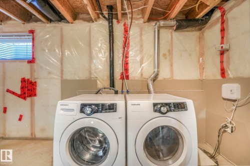 Laundry area with washing machine and dryer and unfinished concrete flooring - 385 Secord Boulevard, Edmonton, AB - Indoor Photo Showing Laundry Room