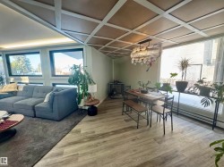 Dining room featuring light wood-type flooring, plenty of natural light, a chandelier, and coffered ceiling - 