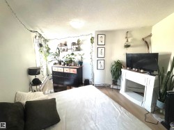 Bedroom featuring a textured ceiling, light wood-style floors, and baseboard heating - 