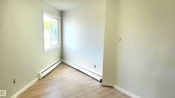Spare room featuring light wood-type flooring, a baseboard radiator, and a textured ceiling - 