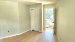 Unfurnished bedroom featuring light wood-style flooring, a closet, a baseboard heating unit, and a textured ceiling - 