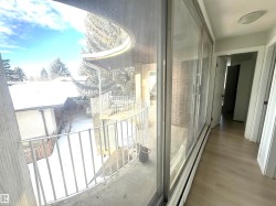 Snow covered back of property featuring baseboard heating - 