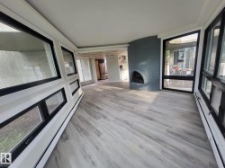 Unfurnished sunroom featuring baseboard heating, a baseboard heating unit, and wood finished floors - 