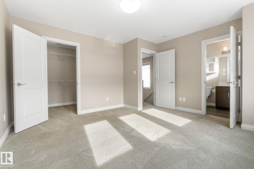 Unfurnished bedroom with light carpet, a walk in closet, and connected bathroom - 332 West Haven Drive, Leduc, AB - Indoor Photo Showing Other Room