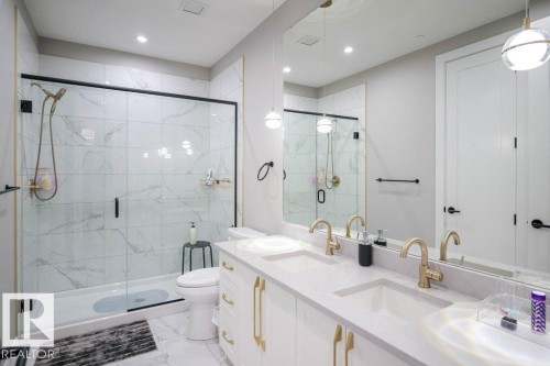 Bathroom featuring double vanity, a marble finish shower, light marble finish flooring, and recessed lighting - 101 7471 May Common, Edmonton, AB - Indoor Photo Showing Bathroom