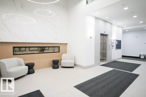 Building lobby with recessed lighting - 101 7471 May Common, Edmonton, AB - Indoor Photo Showing Other Room With Fireplace