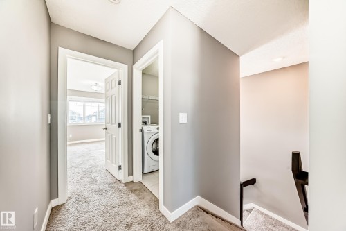 Laundry area featuring light carpet and washer / dryer - 3520 49 Avenue, Beaumont, AB - Indoor Photo Showing Laundry Room