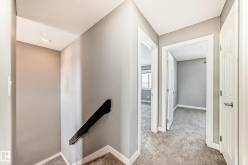Hall featuring light colored carpet and an upstairs landing - 3520 49 Avenue, Beaumont, AB - Indoor Photo Showing Other Room