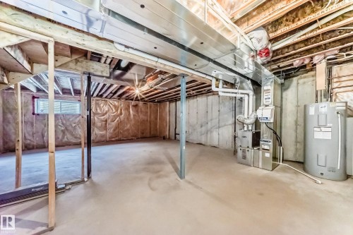Basement featuring water heater and heating unit - 3520 49 Avenue, Beaumont, AB - Indoor Photo Showing Basement