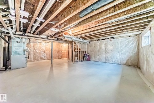 Unfinished below grade area featuring heating unit and stairway - 3520 49 Avenue, Beaumont, AB - Indoor Photo Showing Basement