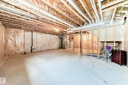 Unfinished basement featuring water heater and heating unit - 3520 49 Avenue, Beaumont, AB - Indoor Photo Showing Basement