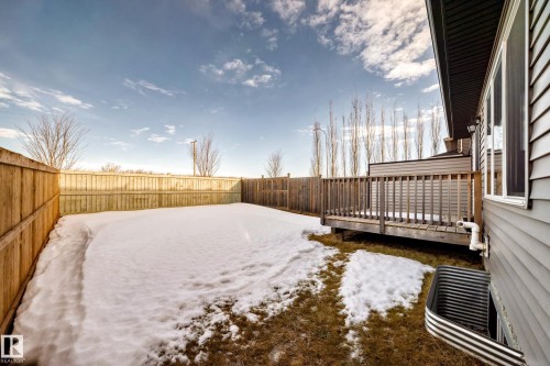 Yard covered in snow featuring a fenced backyard and a wooden deck - 3520 49 Avenue, Beaumont, AB - Outdoor