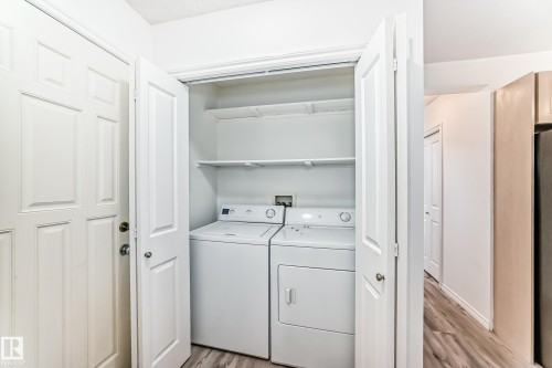 Laundry area with light wood-type flooring and washer and dryer - 4604 202 Street, Edmonton, AB - Indoor Photo Showing Laundry Room