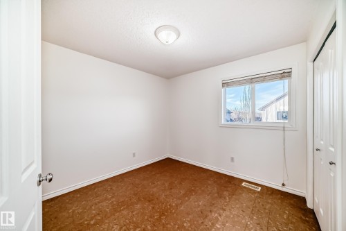 Unfurnished bedroom with a closet and dark floors - 4604 202 Street, Edmonton, AB - Indoor Photo Showing Other Room
