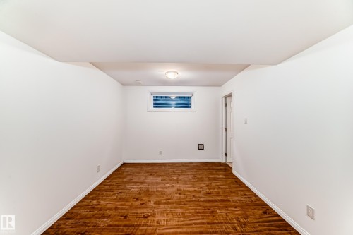 Spare room featuring dark wood-style floors and baseboards - 4604 202 Street, Edmonton, AB - Indoor Photo Showing Other Room