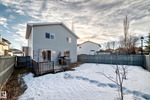 Snow covered back of property with a fenced backyard and a wooden deck - 4604 202 Street, Edmonton, AB - Outdoor With Deck Patio Veranda