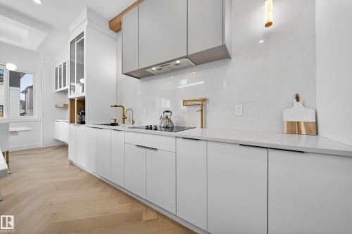 Kitchen with modern cabinets, white cabinets, parquet floors, and glass insert cabinets - 132 29 Street, Edmonton, AB - Indoor Photo Showing Kitchen