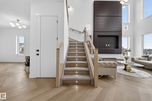 Stairs with parquet flooring, a chandelier, and a towering ceiling - 132 29 Street, Edmonton, AB - Indoor