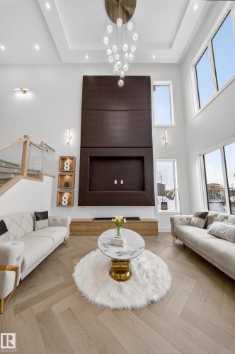 Living area featuring parquet flooring, a tray ceiling, a towering ceiling, and recessed lighting - 132 29 Street, Edmonton, AB - Indoor Photo Showing Living Room