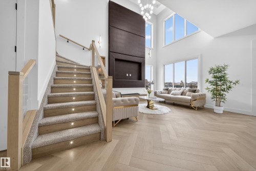 Living room with parquet floors, a chandelier, a towering ceiling, and stairs - 132 29 Street, Edmonton, AB - Indoor