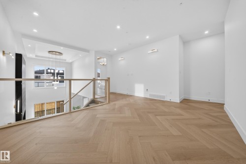 Spare room with a chandelier, parquet flooring, recessed lighting, and a high ceiling - 132 29 Street, Edmonton, AB - Indoor Photo Showing Other Room