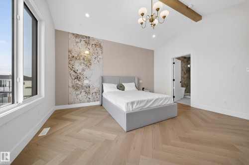 Bedroom featuring parquet floors, a chandelier, an accent wall, recessed lighting, and ensuite bathroom - 132 29 Street, Edmonton, AB - Indoor Photo Showing Bedroom