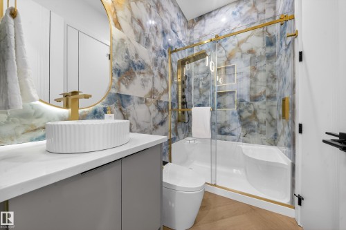 Full bath featuring a marble finish shower, vanity, and light wood finished floors - 132 29 Street, Edmonton, AB - Indoor Photo Showing Bathroom