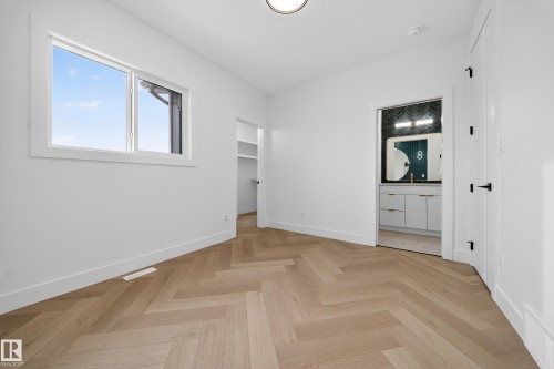 Unfurnished bedroom featuring a spacious closet, parquet floors, and connected bathroom - 132 29 Street, Edmonton, AB - Indoor Photo Showing Other Room