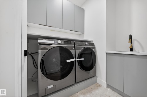 Laundry room with cabinet space and washing machine and clothes dryer - 132 29 Street, Edmonton, AB - Indoor Photo Showing Laundry Room