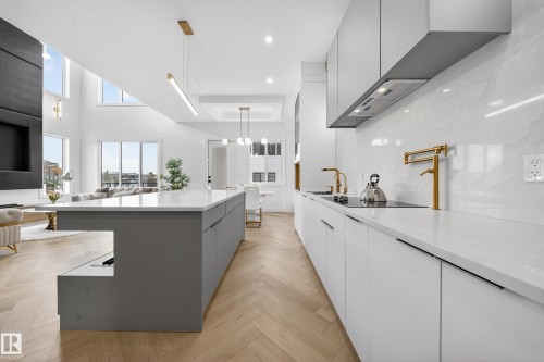 Kitchen with modern cabinets, gray cabinets, white cabinetry, pendant lighting, and parquet flooring - 132 29 Street, Edmonton, AB - Indoor Photo Showing Kitchen With Upgraded Kitchen