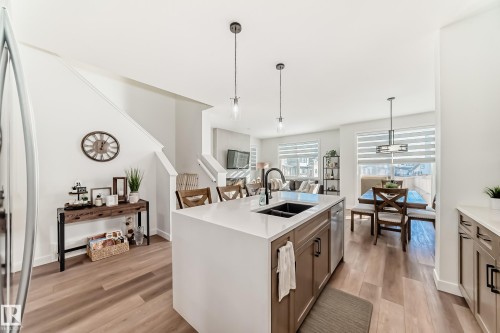 Kitchen with pendant lighting, light wood-style floors, a kitchen island with sink, and light stone countertops - 3569 Erlanger Link, Edmonton, AB - Indoor Photo Showing Kitchen With Double Sink With Upgraded Kitchen