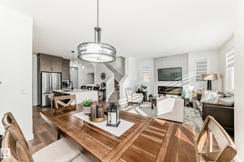 Dining area with dark wood finished floors and a fireplace - 3569 Erlanger Link, Edmonton, AB - Indoor Photo Showing Dining Room