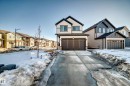Craftsman house featuring a garage, driveway, a residential view, and stone siding - 3569 Erlanger Link, Edmonton, AB  - Outdoor With Facade 