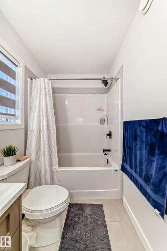 Bathroom featuring shower / bathtub combination with curtain, vanity, and light tile patterned floors - 3569 Erlanger Link, Edmonton, AB - Indoor Photo Showing Bathroom