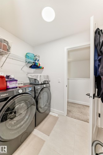 Laundry room featuring light carpet and washing machine and clothes dryer - 3569 Erlanger Link, Edmonton, AB - Indoor Photo Showing Laundry Room