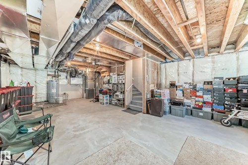 Unfinished below grade area featuring water heater and heating unit - 3569 Erlanger Link, Edmonton, AB - Indoor Photo Showing Basement