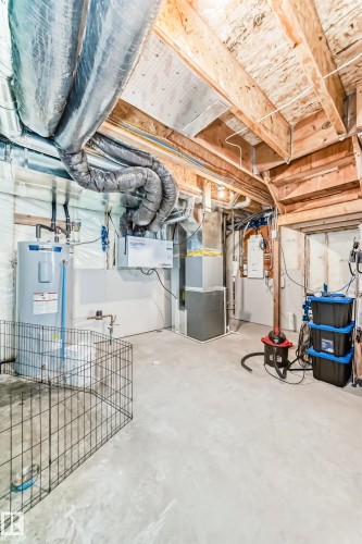 Unfinished below grade area with electric water heater and heating unit - 3569 Erlanger Link, Edmonton, AB - Indoor Photo Showing Basement