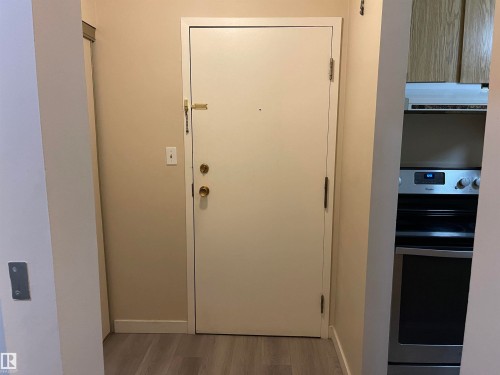 Entryway featuring a solid door, light-toned walls, and wood-look flooring - 311 1624 48 Street, Edmonton, AB - Indoor Photo Showing Other Room