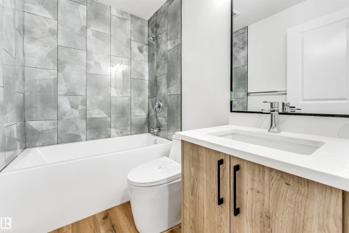 Full bathroom with tub / shower combination, vanity, and wood finished floors - 4616 32 Avenue, Edmonton, AB - Indoor Photo Showing Bathroom