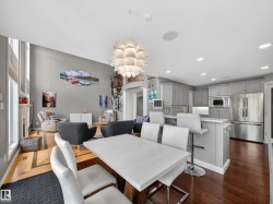 Dining area featuring a fireplace, dark wood-style flooring, and a chandelier - 