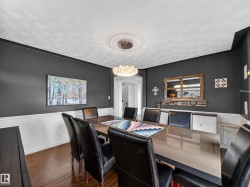 Dining area featuring dark wood-style flooring, arched walkways, and suspended lighting - 