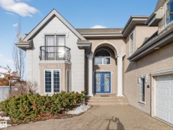 Property entrance featuring french doors, a garage, stucco siding, and a shingled roof - 