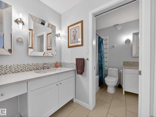 Full bath with vanity, shower / tub combo, decorative backsplash, and light tile patterned flooring - 1062 Tory Road, Edmonton, AB - Indoor Photo Showing Bathroom
