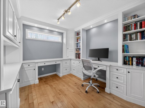 Office space with built in features, built in desk, light wood finished floors, ornamental molding, and rail lighting - 1062 Tory Road, Edmonton, AB - Indoor Photo Showing Office