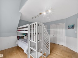 Bedroom featuring track lighting, light wood finished floors, and a closet - 