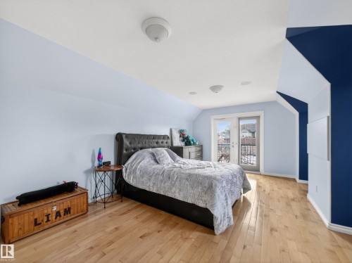 Bedroom with light wood-type flooring, lofted ceiling, and access to outside - 1062 Tory Road, Edmonton, AB - Indoor Photo Showing Bedroom
