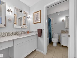 Full bath with vanity, shower / tub combo, decorative backsplash, and light tile patterned flooring - 